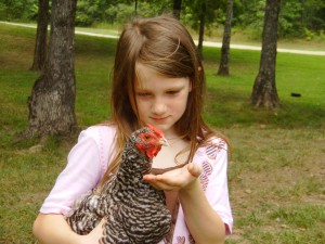 Mary holding a Dominique hen  